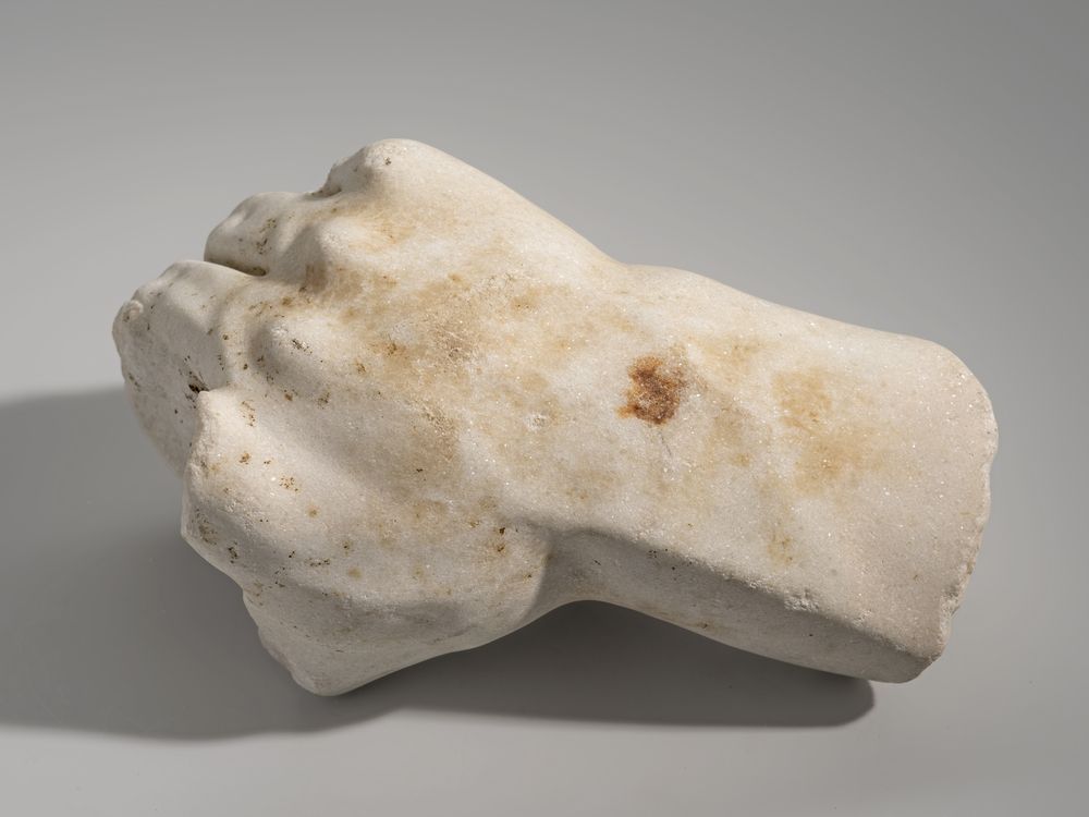 Main droite tenant un objet indéterminé