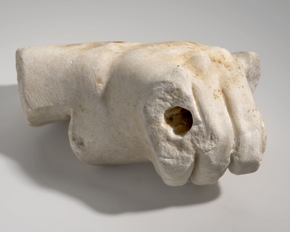 Main droite tenant un objet indéterminé