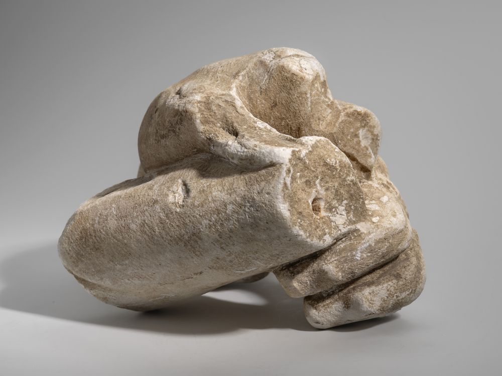 Main gauche tenant un objet indéterminé