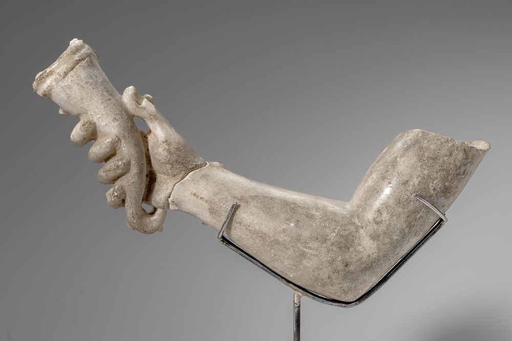 Bras avec main tenant une corne à boire